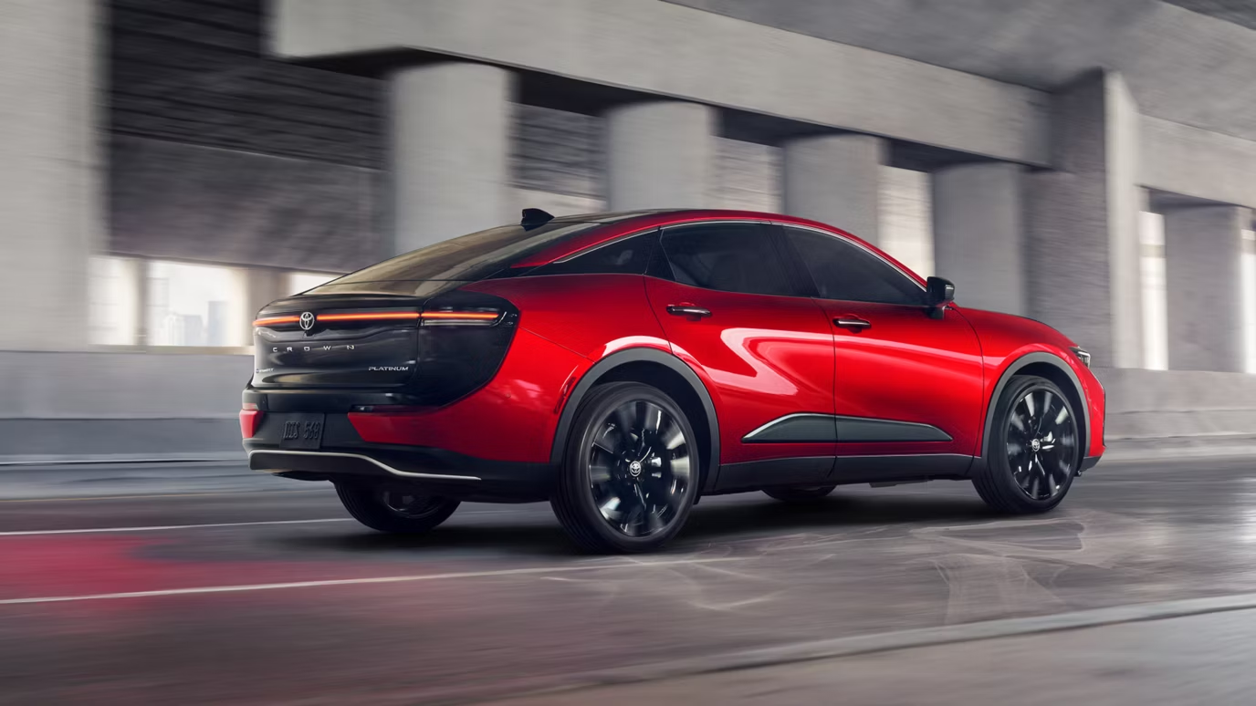 Toyota Crown Crossover สีแดง มุมมองด้านหลังขณะขับขี่บนถนนในเมือง